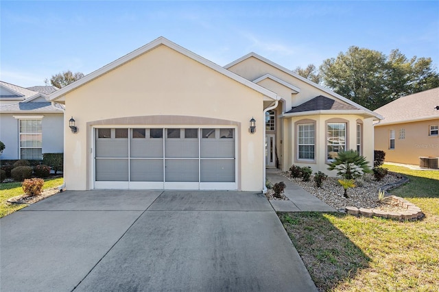 view of front of home with a garage, central AC unit, and a front lawn