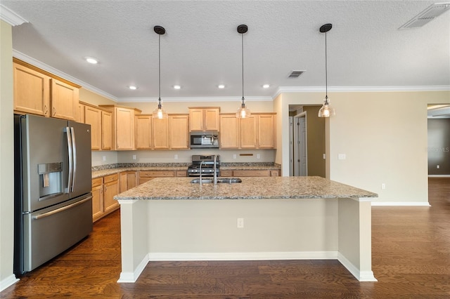 kitchen featuring light stone countertops, decorative light fixtures, stainless steel appliances, and a center island with sink