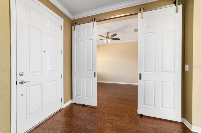 interior space with ornamental molding, a barn door, and dark hardwood / wood-style flooring