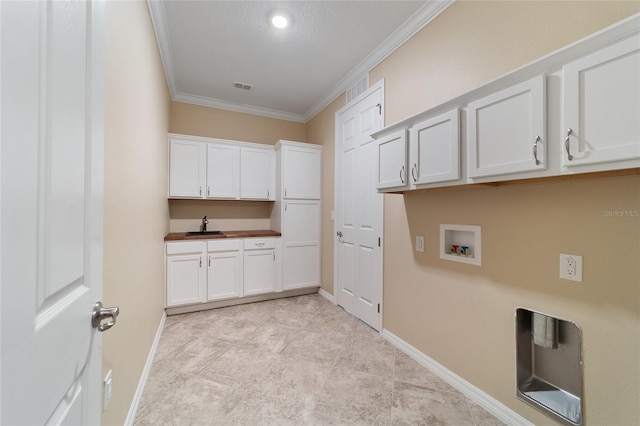 laundry area with sink, crown molding, cabinets, and a textured ceiling