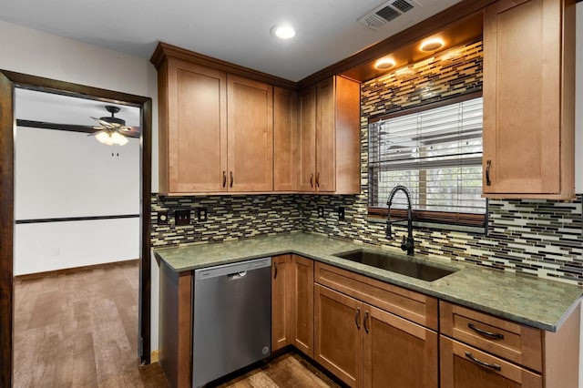 kitchen with tasteful backsplash, sink, stainless steel dishwasher, light stone countertops, and dark wood-type flooring