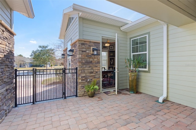 property entrance featuring stone siding and a gate