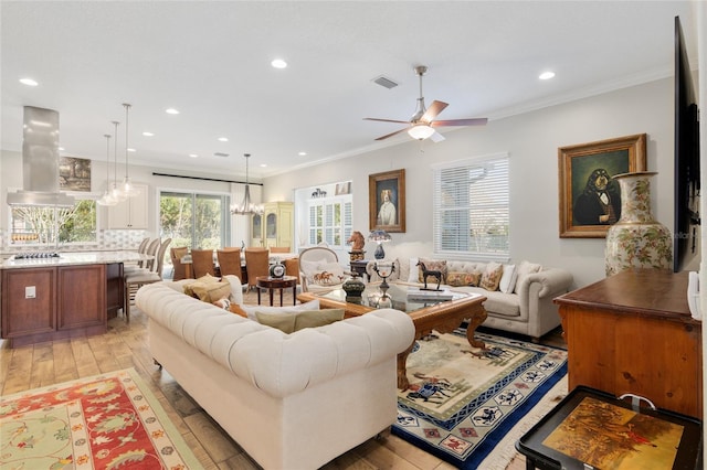 living area featuring recessed lighting, light wood-style flooring, visible vents, and ornamental molding