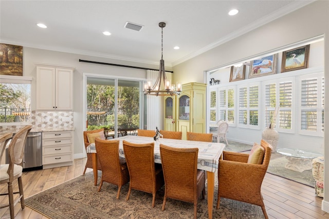 dining area with crown molding, recessed lighting, visible vents, an inviting chandelier, and light wood-type flooring