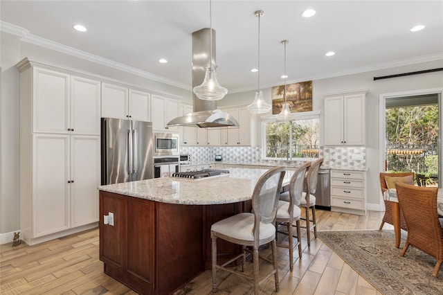 kitchen featuring a kitchen island, appliances with stainless steel finishes, light wood-type flooring, tasteful backsplash, and crown molding