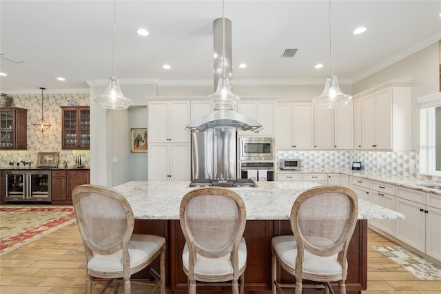 kitchen featuring wine cooler, glass insert cabinets, stainless steel appliances, and ornamental molding