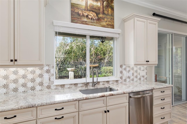 kitchen featuring tasteful backsplash, dishwasher, light stone counters, light wood-type flooring, and a sink