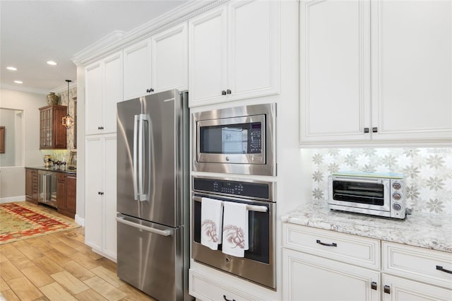 kitchen with appliances with stainless steel finishes, backsplash, white cabinetry, and a toaster