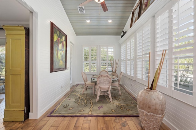 sunroom / solarium featuring lofted ceiling, wooden ceiling, visible vents, and a ceiling fan