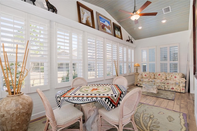 sunroom / solarium with lofted ceiling, wooden ceiling, visible vents, and a ceiling fan