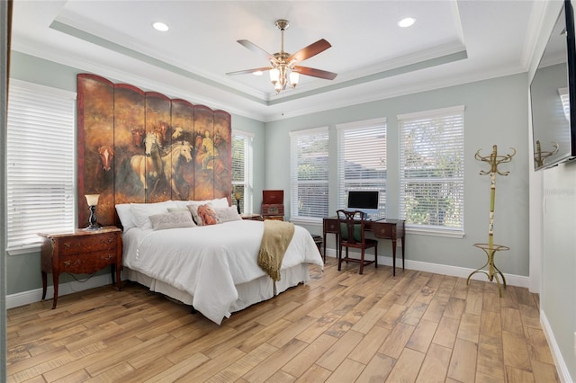 bedroom featuring light wood-style floors, a raised ceiling, and multiple windows