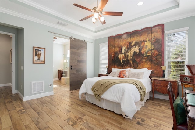 bedroom with light wood-type flooring, a raised ceiling, visible vents, and crown molding