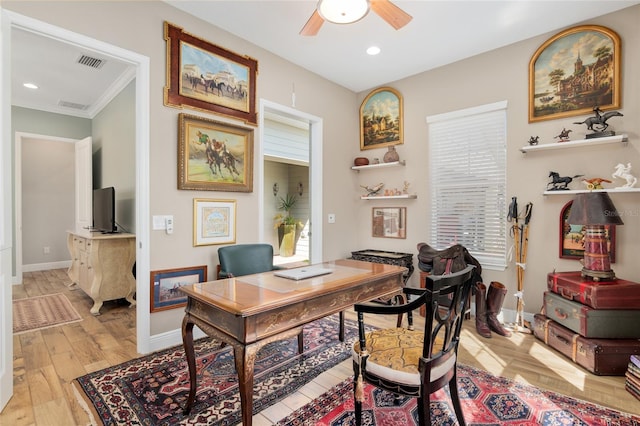 office space with light wood-style floors, baseboards, visible vents, and a ceiling fan