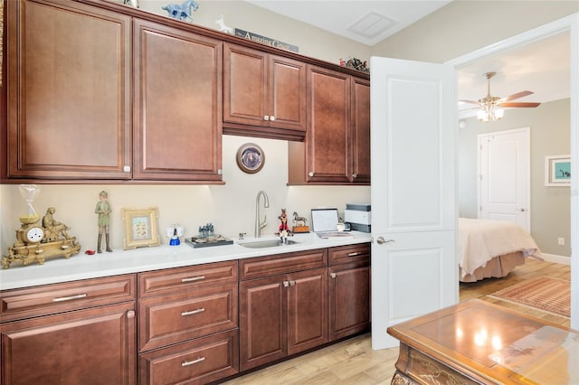 kitchen with ceiling fan, light countertops, a sink, and visible vents