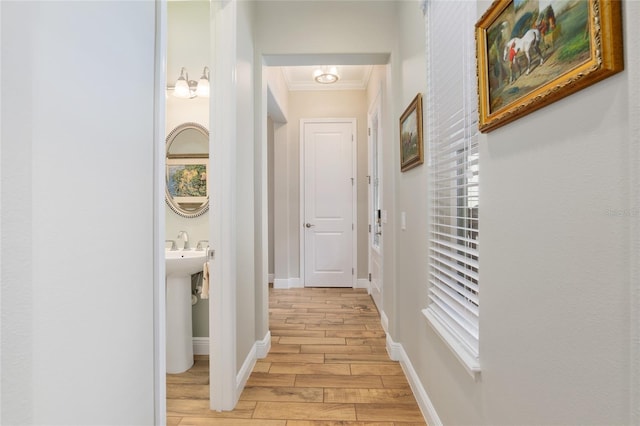 corridor featuring ornamental molding, wood tiled floor, and baseboards