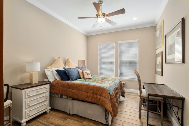 bedroom with baseboards, ornamental molding, and wood finished floors