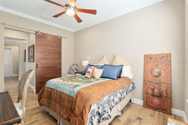 bedroom featuring ornamental molding, wood finished floors, visible vents, and baseboards