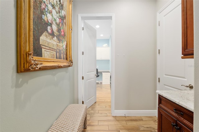 corridor with wood finish floors, baseboards, and recessed lighting