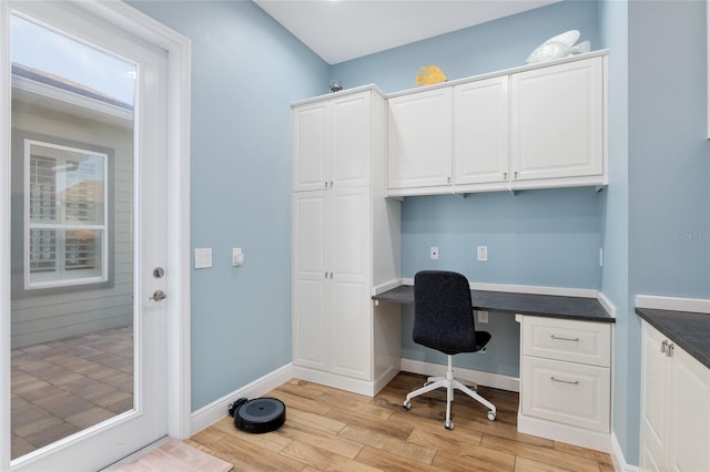 office with light wood-type flooring, baseboards, and built in study area