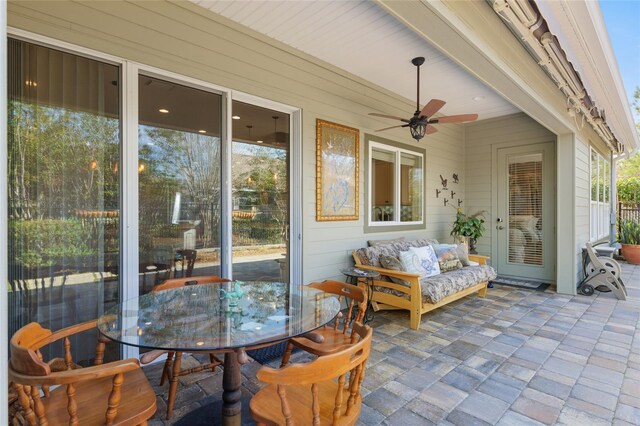 view of patio featuring an outdoor living space, outdoor dining area, and a ceiling fan