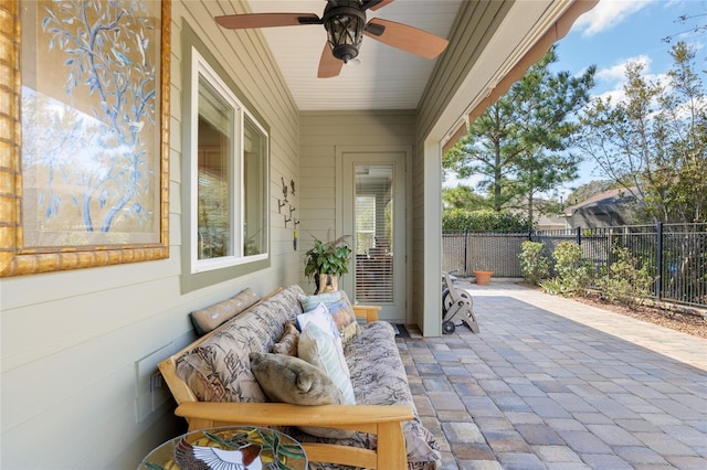 view of patio with a ceiling fan, fence, and an outdoor living space