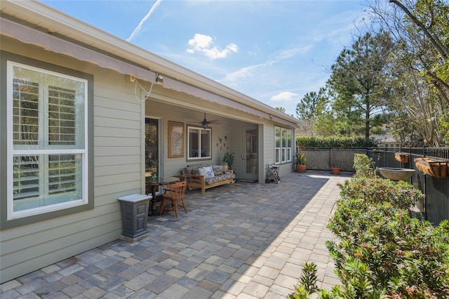 view of patio with an outdoor hangout area, fence, and a ceiling fan