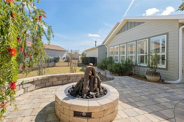 view of patio with an outdoor fire pit and fence