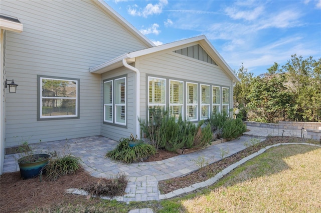 view of side of home featuring a patio and board and batten siding