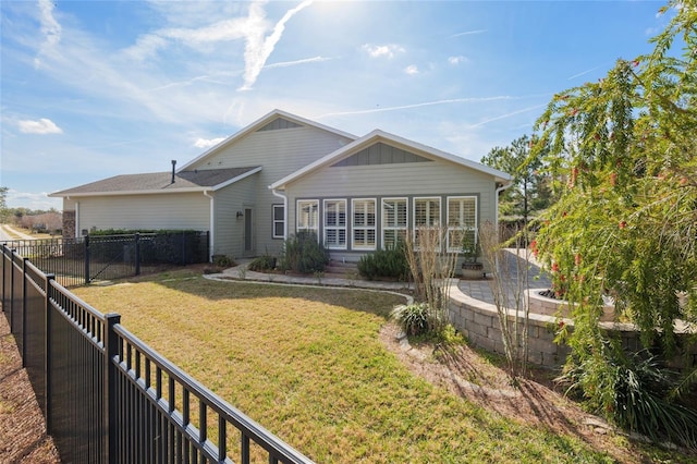 view of front facade with a front lawn and a fenced backyard