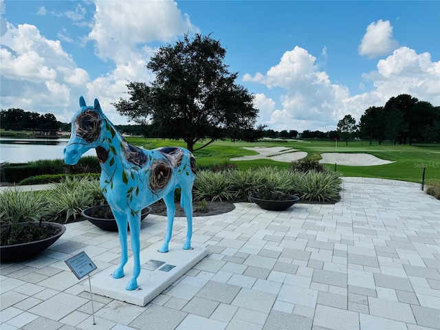 view of home's community featuring view of golf course and a patio area