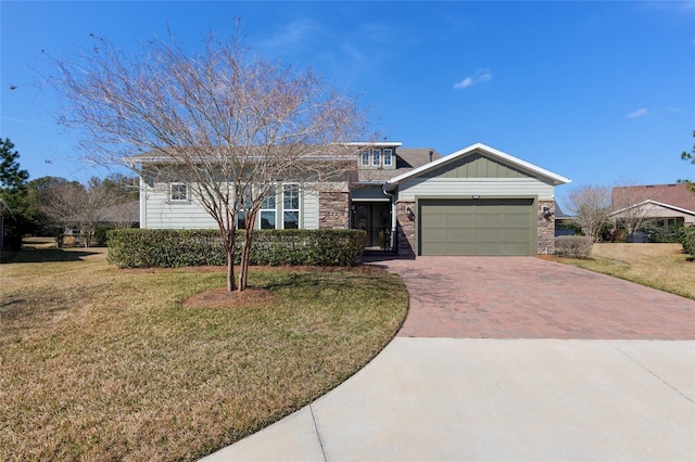 view of front facade with an attached garage, board and batten siding, decorative driveway, and a front yard