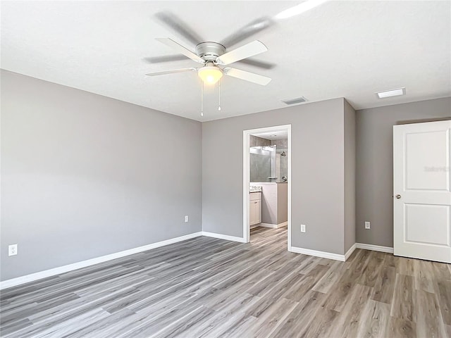 unfurnished bedroom featuring ceiling fan, connected bathroom, and light wood-type flooring