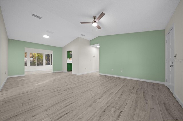 empty room featuring vaulted ceiling, light hardwood / wood-style floors, and ceiling fan