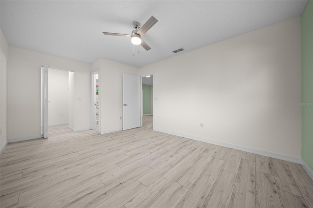 spare room with ceiling fan and light wood-type flooring