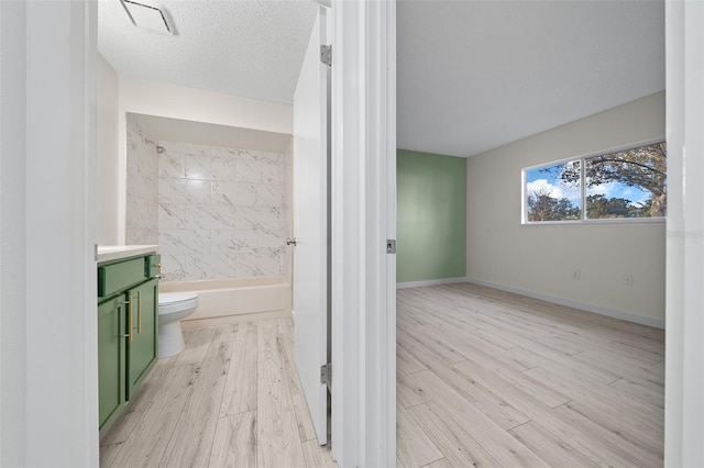 full bathroom featuring vanity, a textured ceiling, wood-type flooring, and toilet