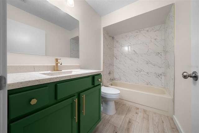 full bathroom with vanity, tiled shower / bath combo, toilet, and a textured ceiling