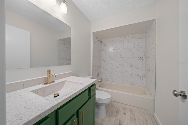 full bathroom featuring hardwood / wood-style floors, tiled shower / bath combo, vanity, a textured ceiling, and toilet