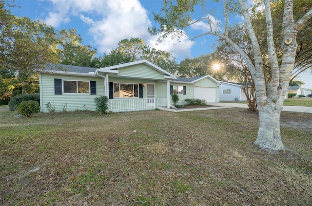 ranch-style home featuring a porch, a garage, and a front lawn