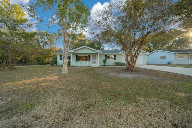 ranch-style house with a garage, a front yard, and covered porch