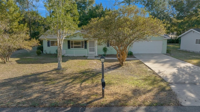 view of front of property with a garage, covered porch, and a front yard