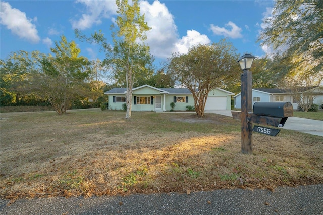 single story home featuring a porch, a garage, and a front yard