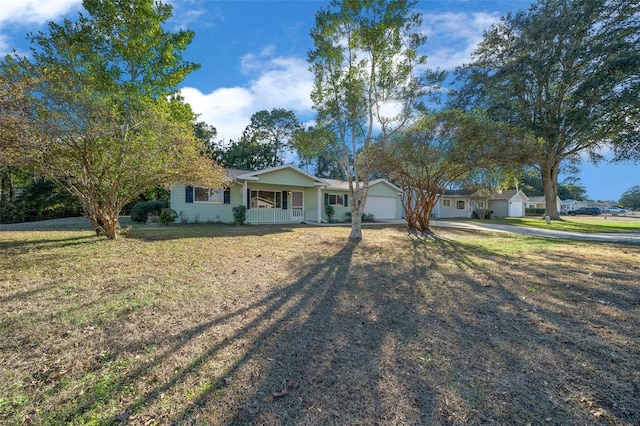 single story home with a garage, covered porch, and a front yard