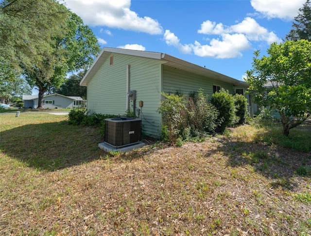 7556 SW 112th Ln, Ocala, FL 34476 - view of side of home with a lawn and central AC