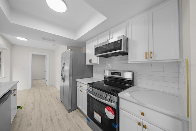 7556 SW 112th Ln, Ocala, FL 34476 - kitchen featuring tasteful backsplash, visible vents, white cabinetry, a raised ceiling, and appliances with stainless steel finishes