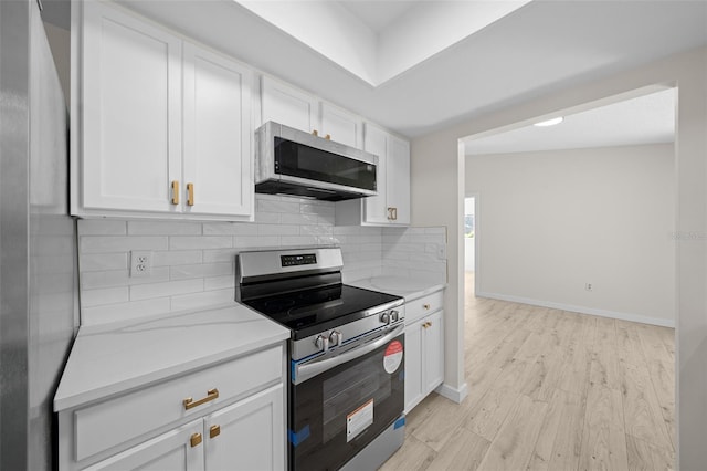 7556 SW 112th Ln, Ocala, FL 34476 - kitchen with appliances with stainless steel finishes, backsplash, white cabinetry, light wood-type flooring, and baseboards
