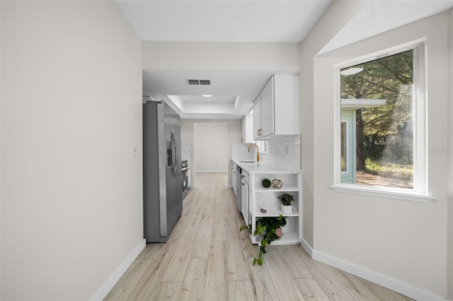 7556 SW 112th Ln, Ocala, FL 34476 - hall with a tray ceiling, baseboards, light wood finished floors, and a sink