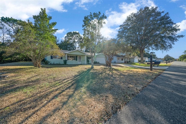 7556 SW 112th Ln, Ocala, FL 34476 - view of front of house featuring covered porch, driveway, a front lawn, and a garage