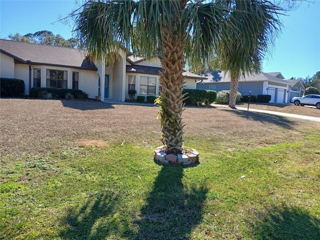 view of front of property featuring a garage, a front lawn, and stucco siding