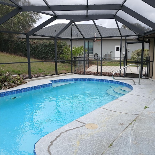 outdoor pool with a patio area, a lanai, and central air condition unit