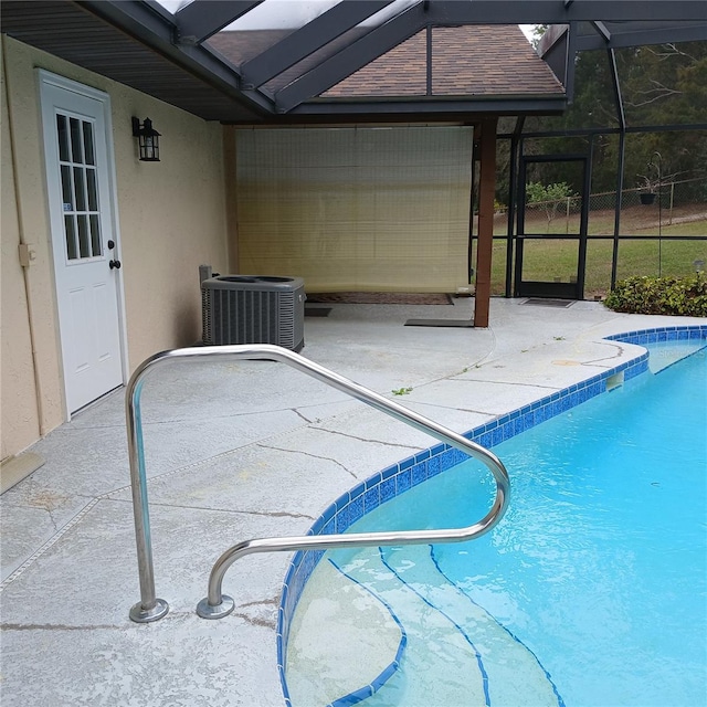 pool featuring a lanai, central AC unit, and a patio